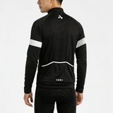 Person wearing black cycling jersey and shorts with white reflective accents on a light gray background