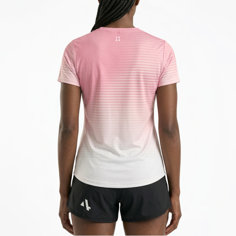 Back view of woman wearing a pink and white gradient running t-shirt and black running shorts on a white background